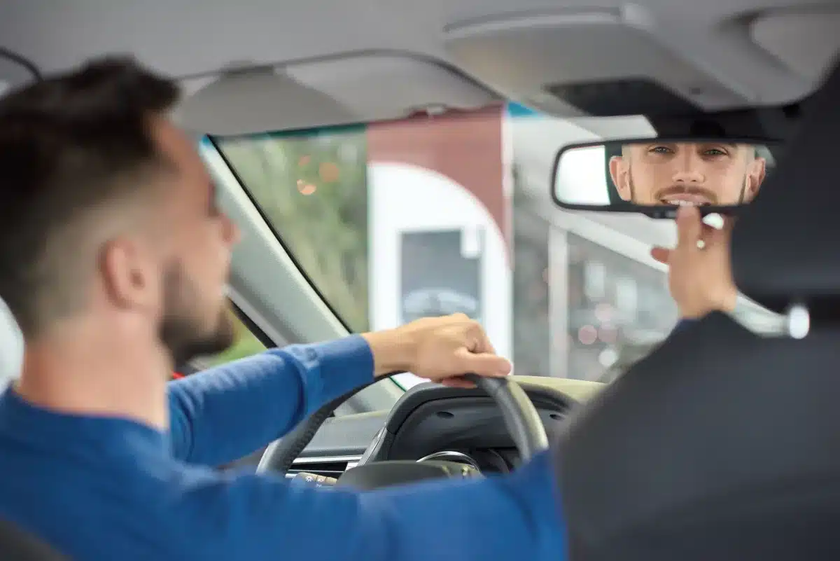 נהג מכוונן את מושב הרכב ובודק את המראות לפני תחילת הנסיעה